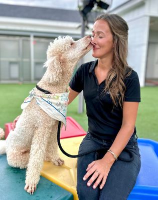 a woman kissing a dog
