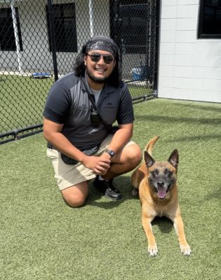 a man kneeling next to a dog