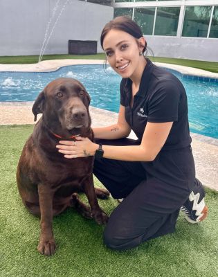 a woman kneeling next to a dog